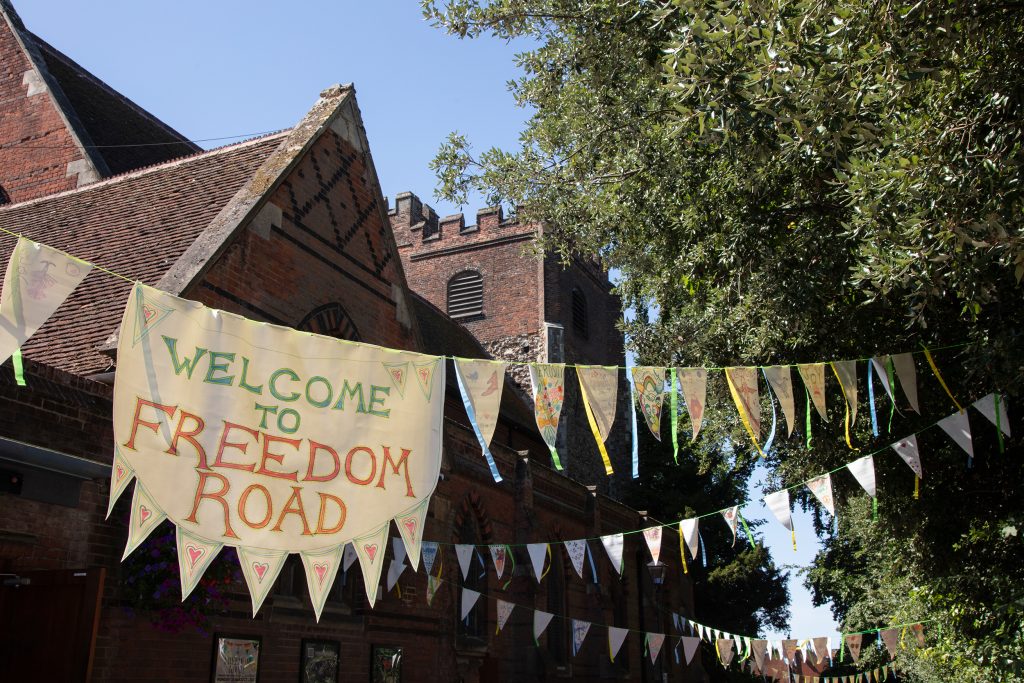 Bunting strung outdoors, with a large panel reading 'Freedom Road'